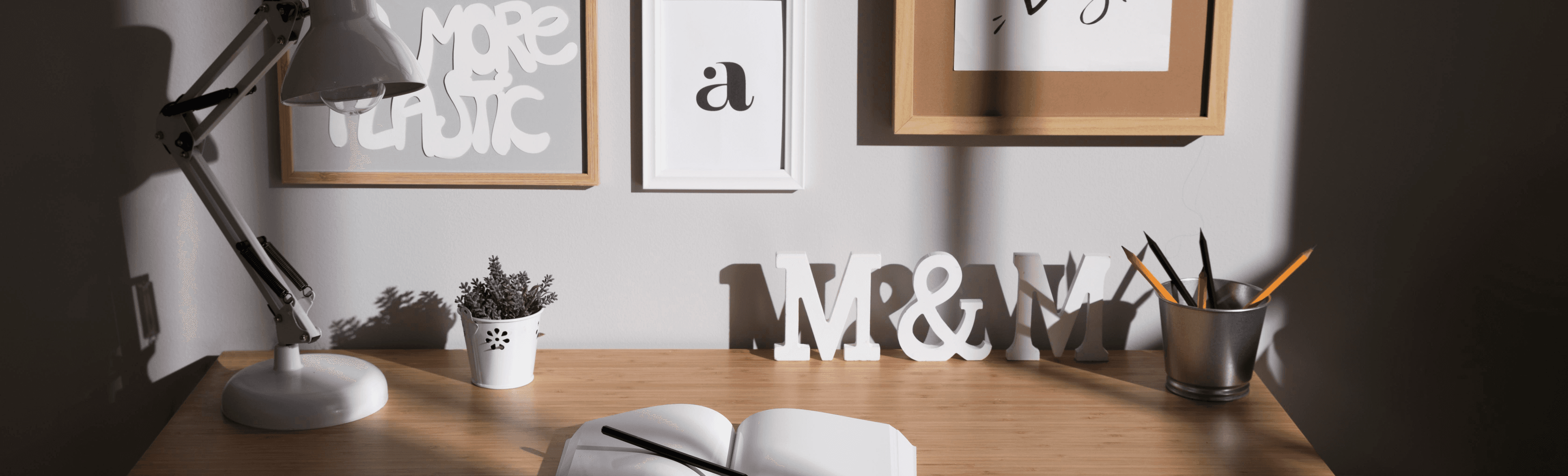 Okolí pracovního stolu vyzdobeno fotografiemi