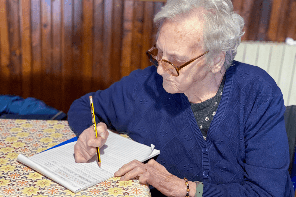 Starší paní sepisuje dědickou smluvu.